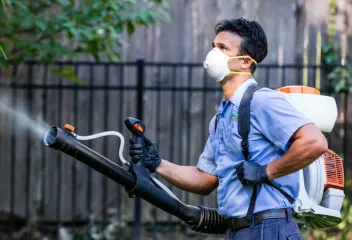Dial Environmental technician spraying outside for mosquitoes