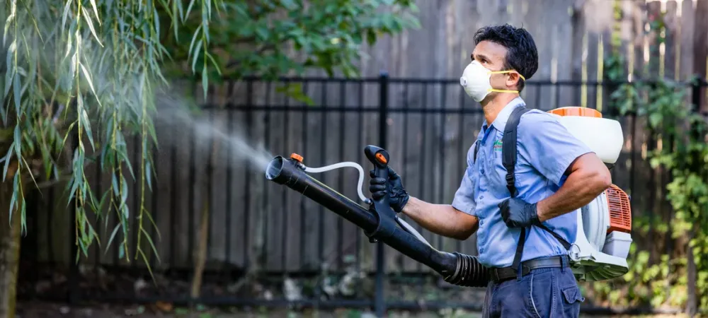 Dial Environmental technician spraying outside for mosquitoes