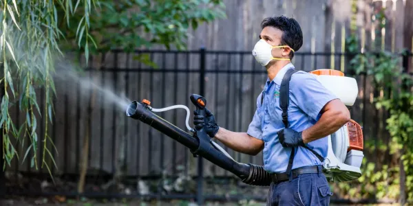 Dial Environmental technician spraying outside for mosquitoes